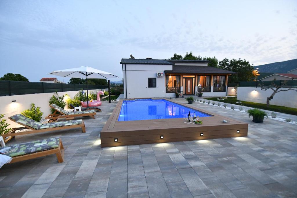 a backyard with a swimming pool and a house at Palomino house in Sinj