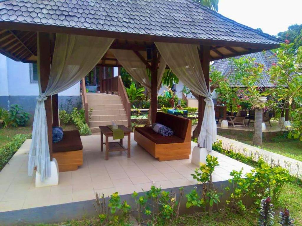 a gazebo with two couches and a table at Araminth Guest House and Spa in Lovina
