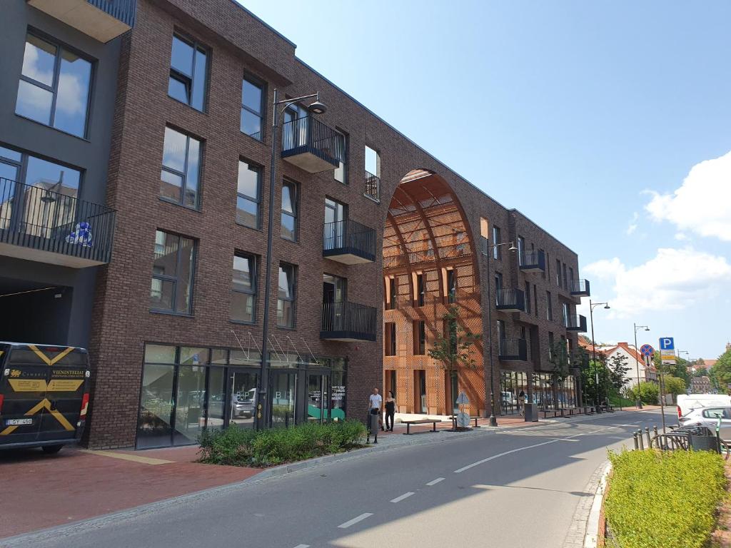 um edifício de tijolos numa rua com uma pessoa a descer a rua em New cozy apartment in the old town of Vilnius, Paupys em Vilnius