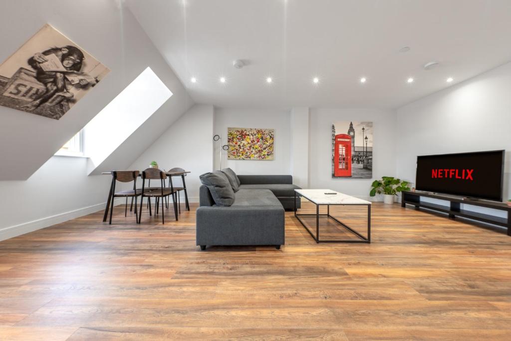 倫敦的住宿－7 - West London Brand New Loft，带沙发和电视的客厅