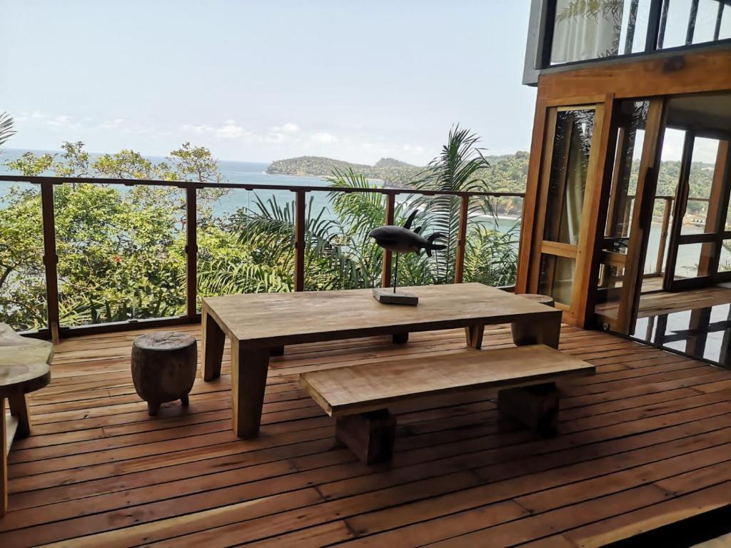 eine Holzterrasse mit einem Tisch und einer Bank darauf in der Unterkunft Takina house in SantʼAna