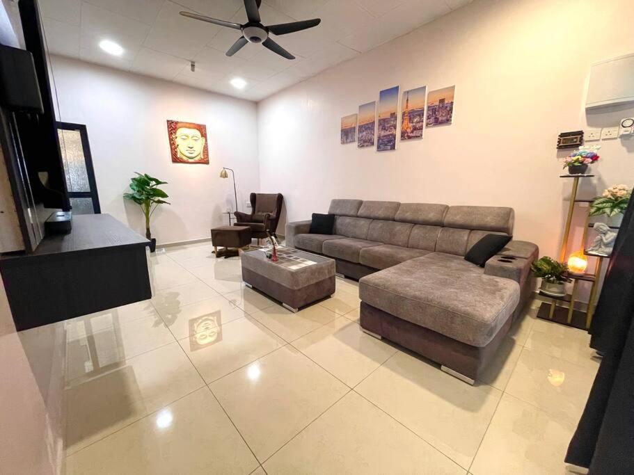 sala de estar con sofá y mesa en Cozy Stay At Raintown Taiping, en Kamunting