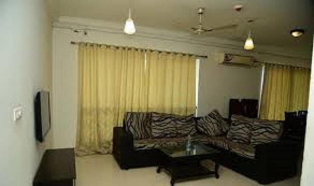 ein Wohnzimmer mit einem Sofa und einem Couchtisch in der Unterkunft Oragadam Rooms By Actisai in Oragadam