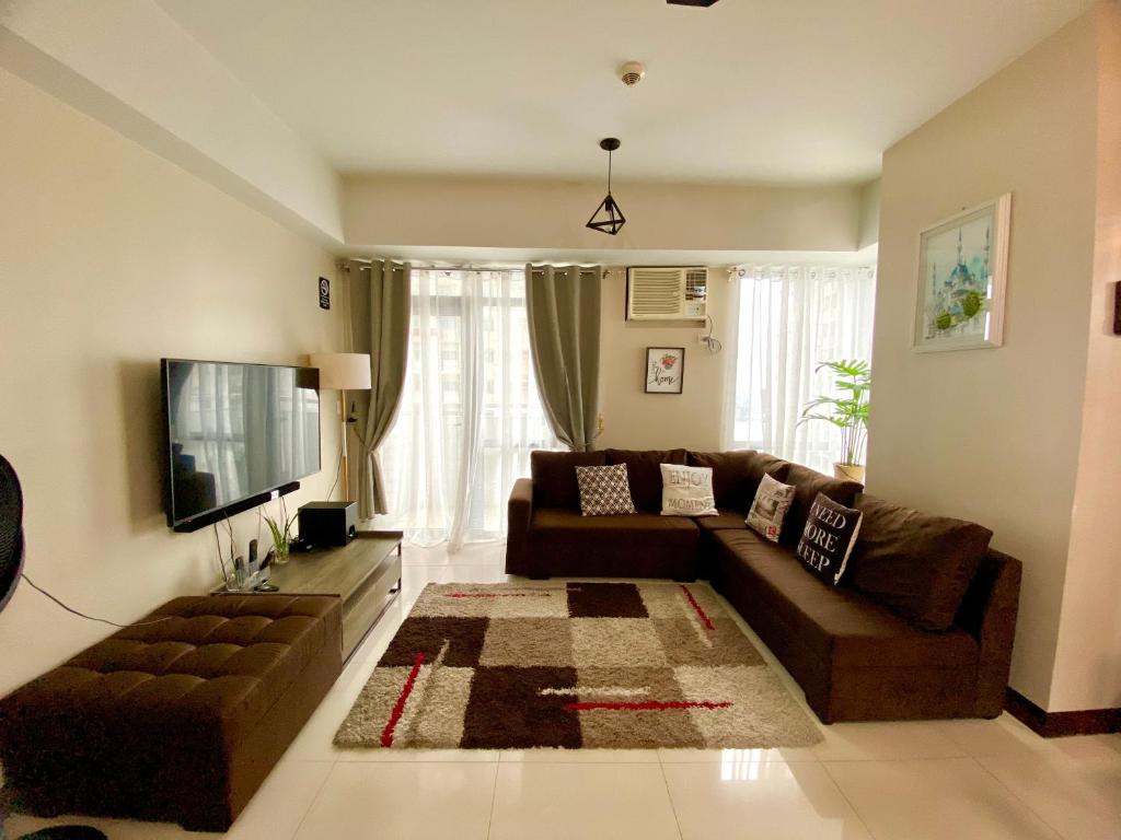 a living room with a couch and a television at Frost at Manhattan Heights TowerB in Manila