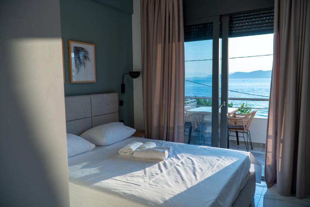 a bedroom with a bed with a view of the ocean at suite apartment Αdonis in Agiokampos
