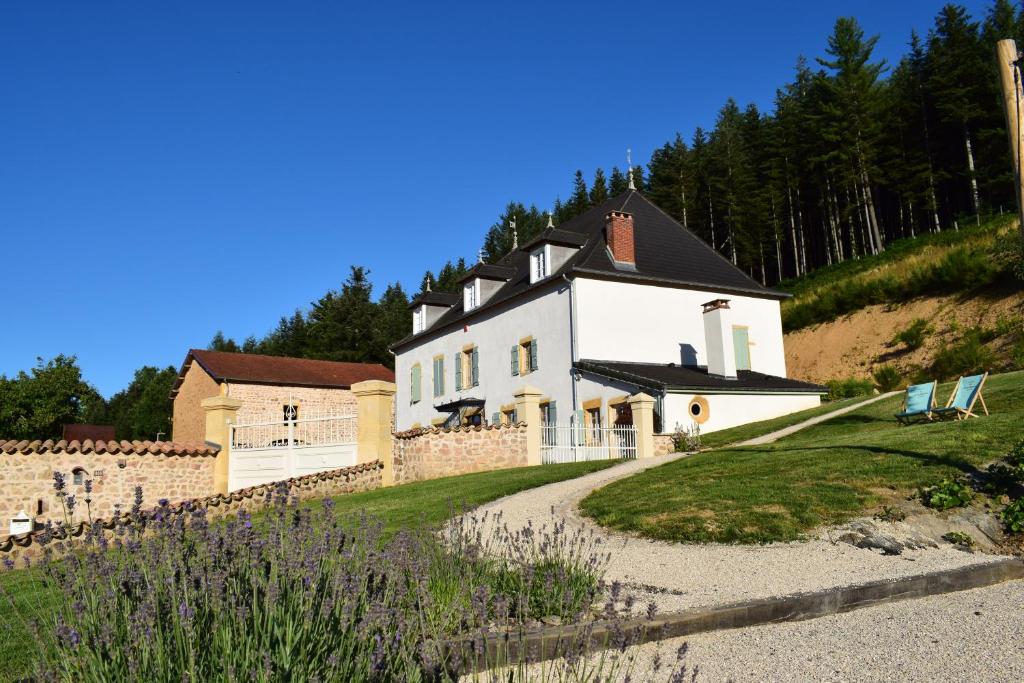 une grande maison blanche au sommet d'une colline dans l'établissement Le Domaine de la Source, à Chauffailles