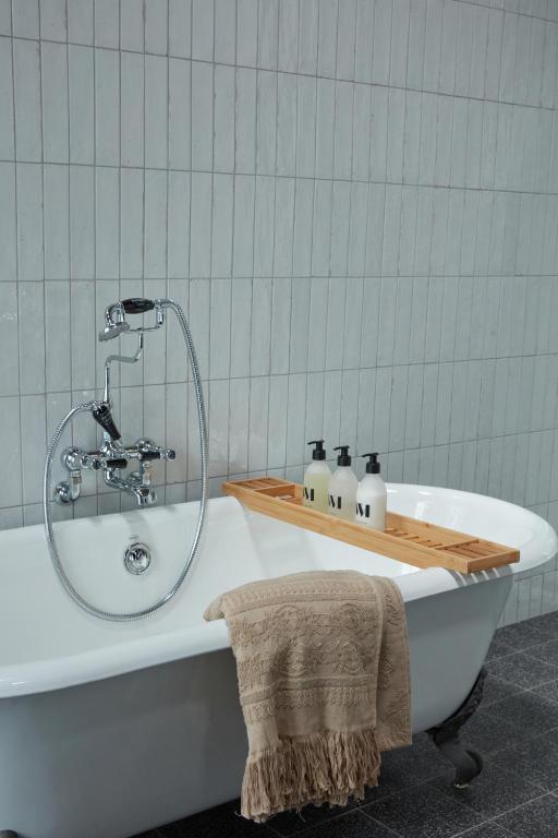 a bath tub with a shower in a bathroom at DOMAINE LE MEZO in Ploeren