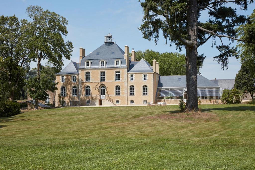 a large house on a grassy hill with a tree at DOMAINE LE MEZO in Ploeren