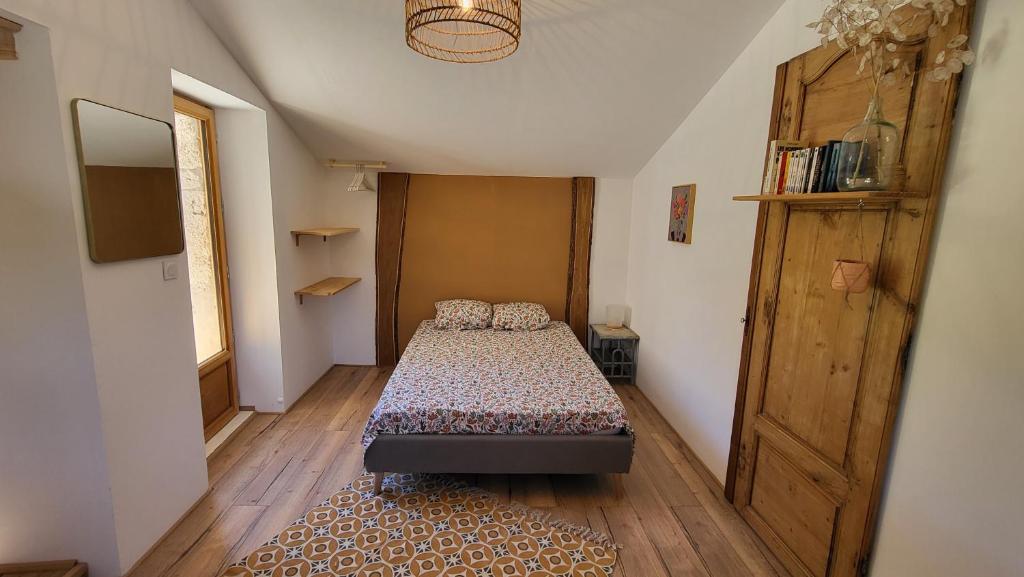 een slaapkamer met een bed en een houten vloer bij Ferme de Lacassagne in Vazerac