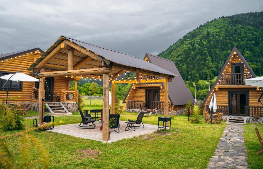 Cabaña de madera con terraza con mesa y sillas en Eco House Borjomi en Borjomi