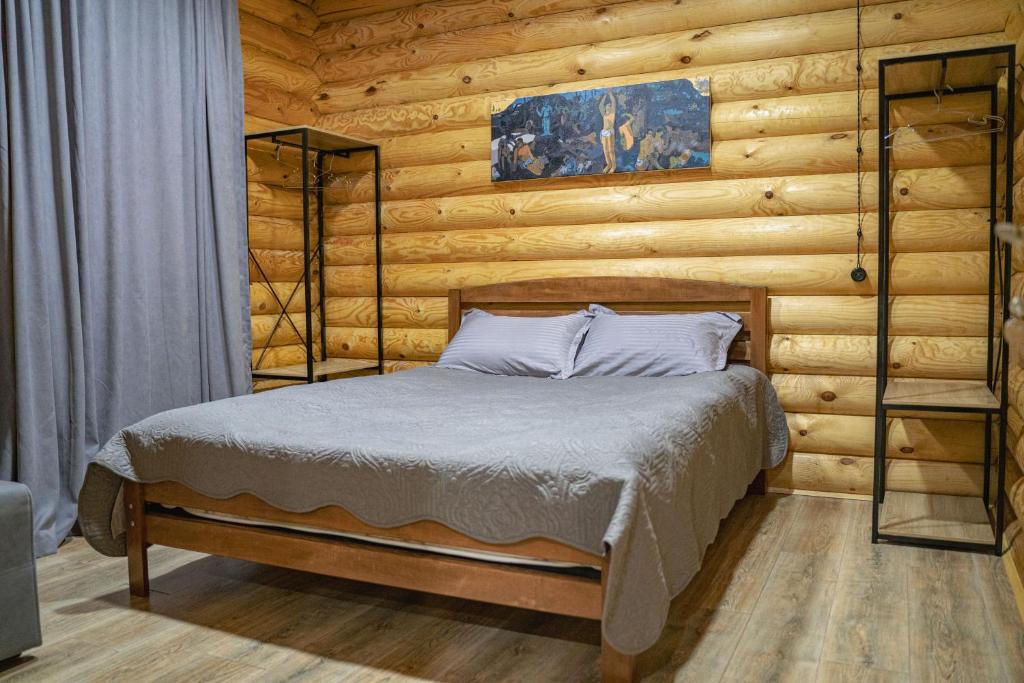 Eco House Borjomi في بورجومي: غرفة نوم بسرير في جدار خشبي