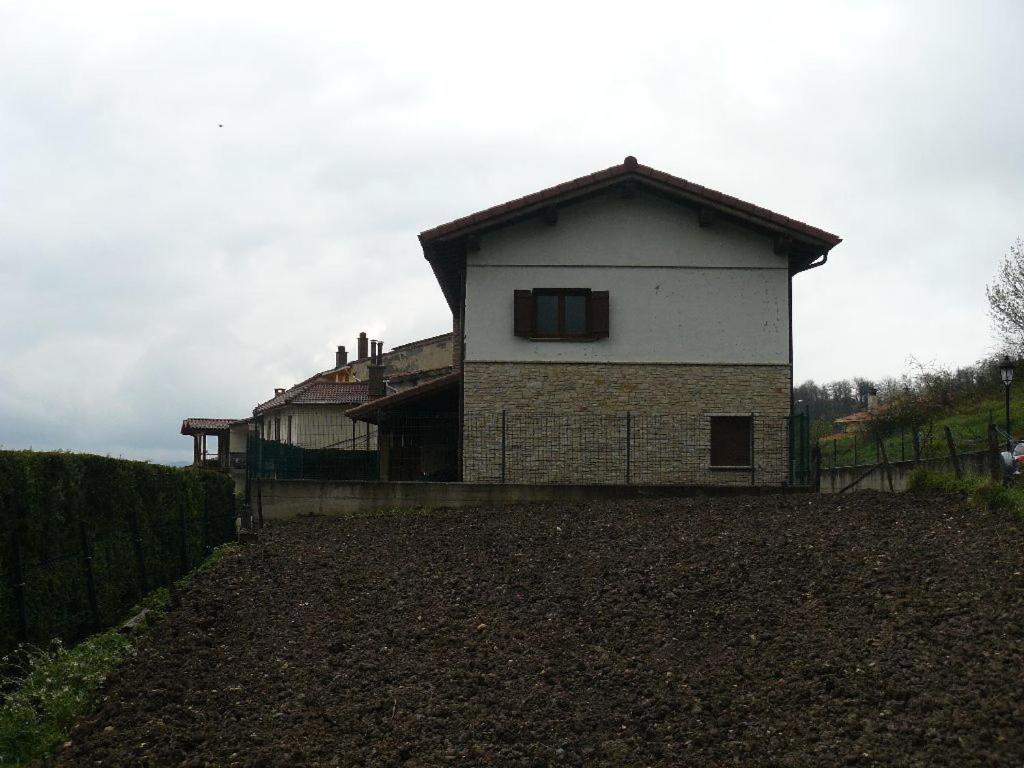 een huis in een veld naast een hek bij Etxeondo in Torrano