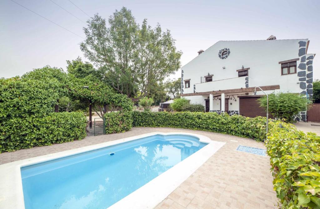 a swimming pool in front of a house at Alojamientos Rurales Berrocal in Berrocal