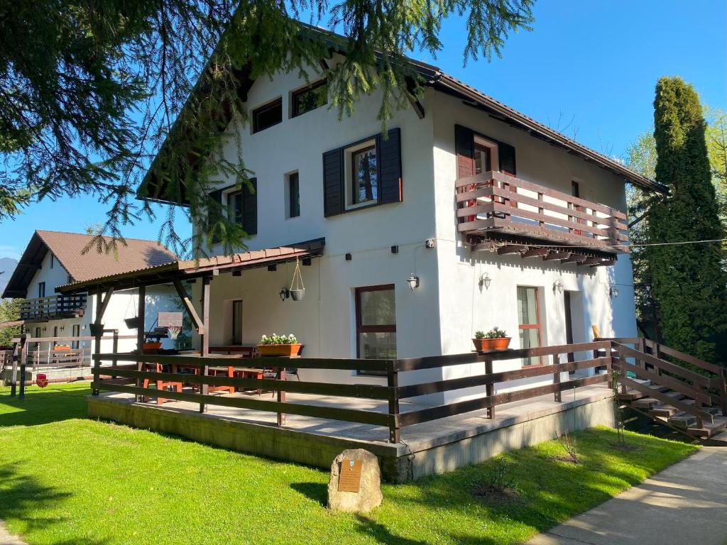 uma grande casa branca com uma grade de madeira em Vila Alunis 1 em Bran