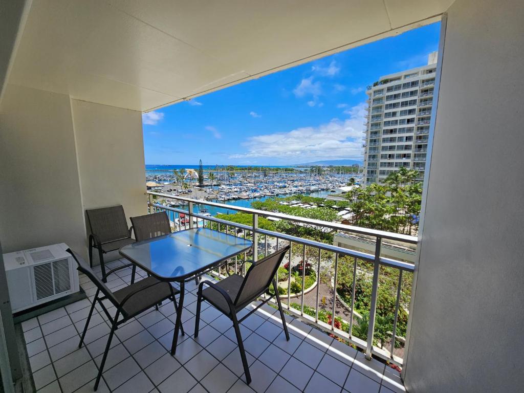 a balcony with a table and chairs and a view of the city at Ilikai Hotel Condo with Kitchen and Ocean View in Honolulu