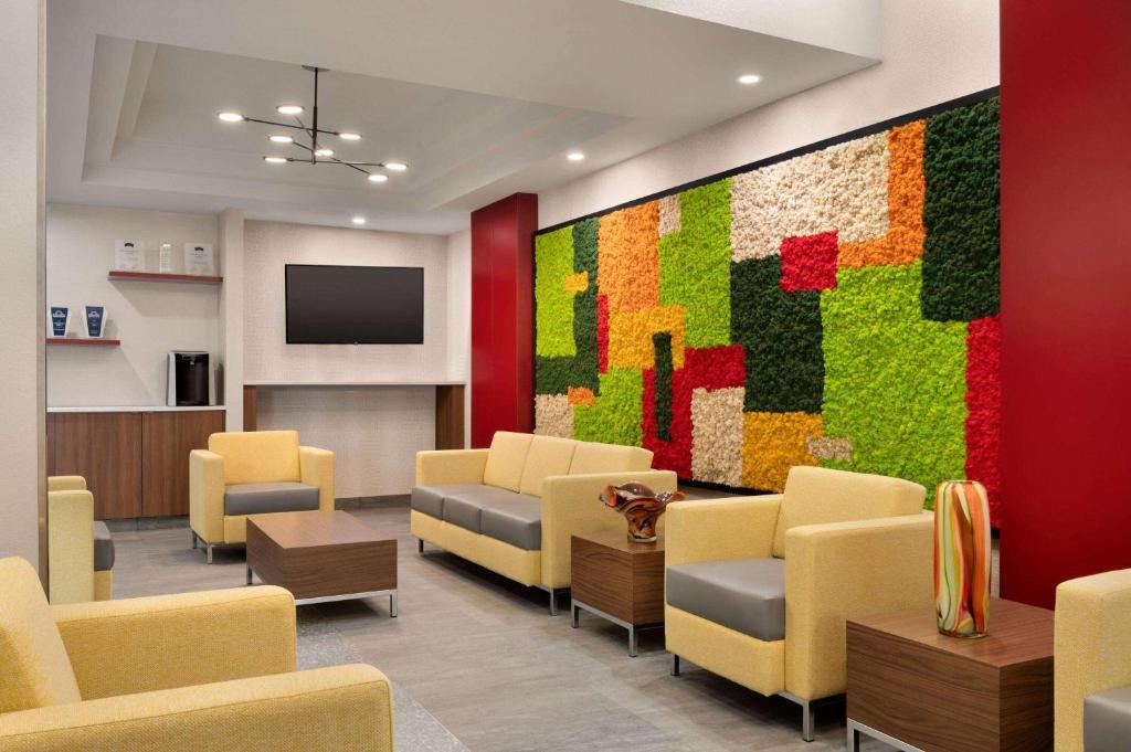 una sala de espera con sillas amarillas y una pared colorida en Days Inn & Suites by Wyndham Sherwood Park Edmonton, en Sherwood Park