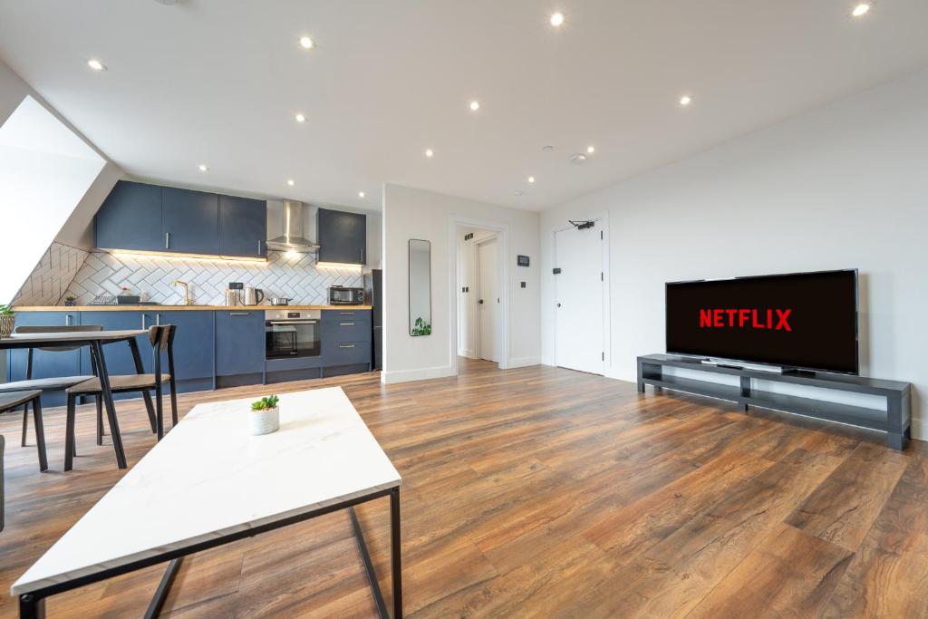 uma cozinha e sala de estar com uma televisão e uma mesa em 8 - West London Brand New Loft em Londres