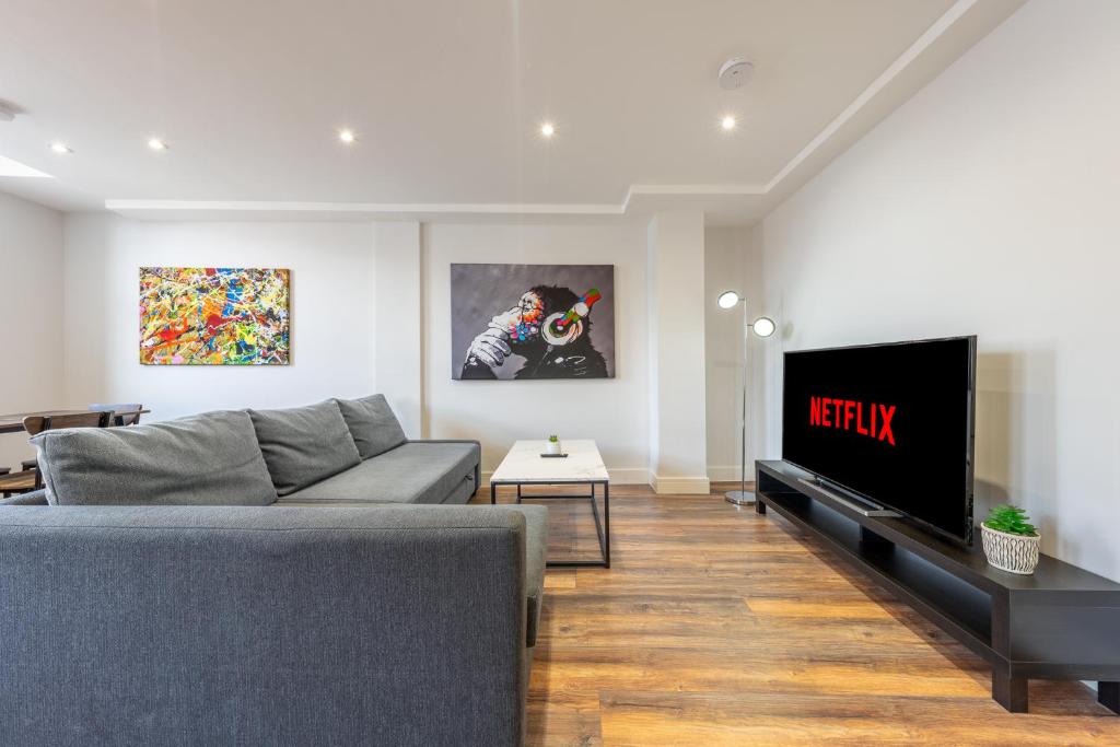 un soggiorno con divano e TV a schermo piatto di 6 - West London Brand New Loft a Londra