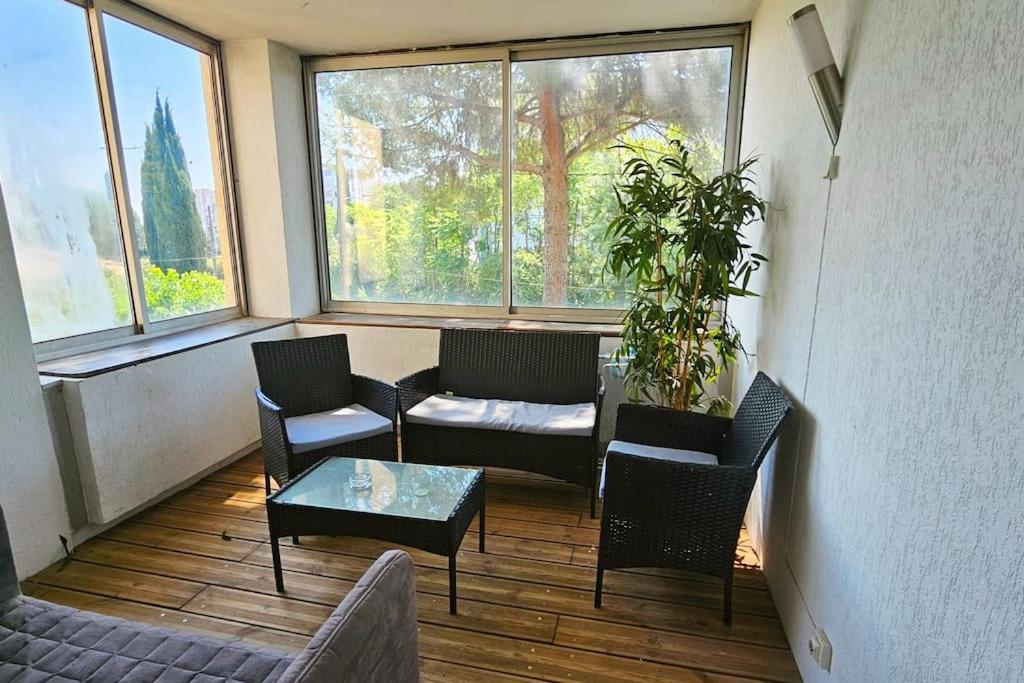 un salon avec un canapé, des chaises et une table dans l'établissement Ovalie ! Spacieux T3 lumineux, à Montpellier