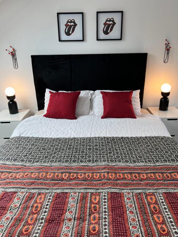 1 dormitorio con 1 cama grande con almohadas rojas en En-suite Room 6-mins walk to Tooting Broadway Tube Station, en Londres