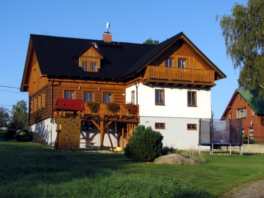 une grande maison en bois avec un toit noir dans l'établissement Pension Polubný 922, à Kořenov