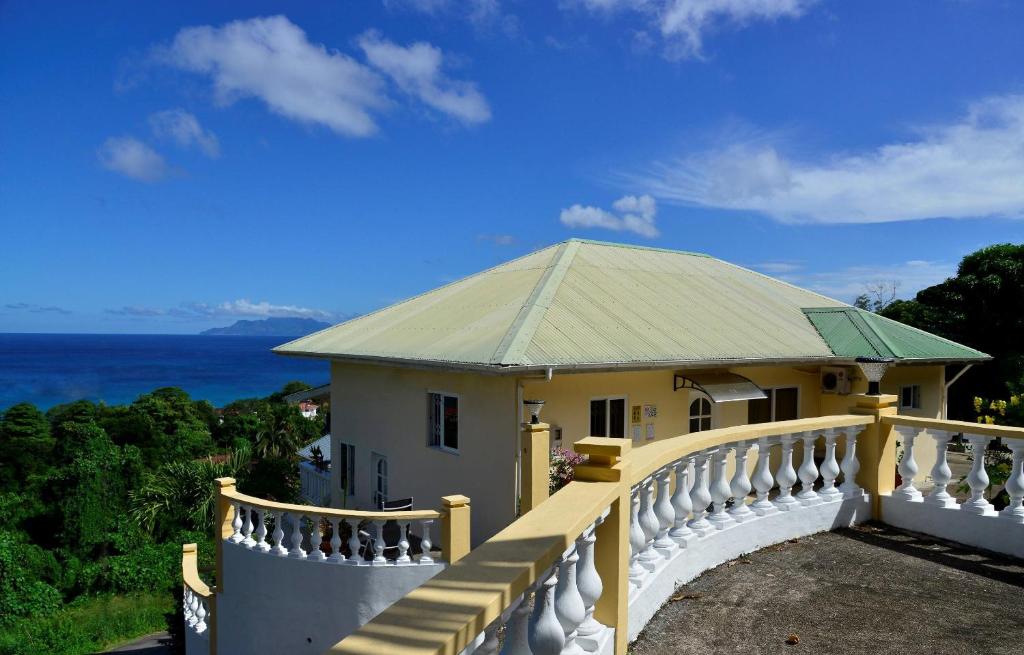 uma casa com uma varanda com vista para o oceano em Haus Megan em Mahé