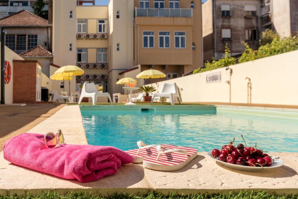 - une piscine avec 2 serviettes et un bol de fruits à côté de la piscine dans l'établissement 733 Costa Cabral Metro Residence, à Porto