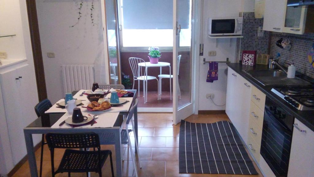 una piccola cucina con tavolo e sedie di Casa Vacanze Orchidea CIR0347AT00249 a Parma