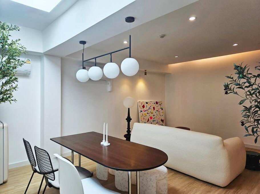 a dining room with a table and a couch at PB home 1 min to BTS Saladaeng & MRT Silom in Bang Rak