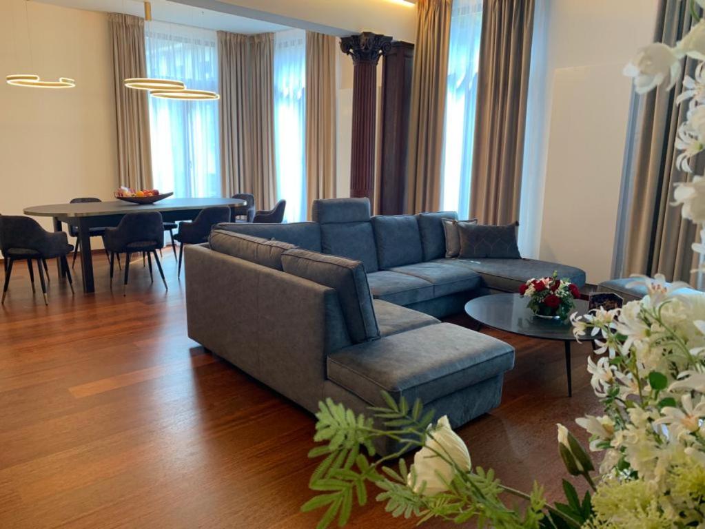 een woonkamer met een blauwe bank en een tafel bij Botanique Suites AirBnB, Antwerp in Antwerpen