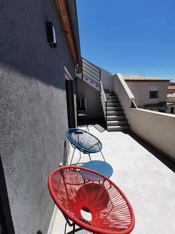deux chaises et une table sur un balcon dans l'établissement AS22351 - P3 au 2ème et dernier étage dans une résidence neuve en Centre Ville, au Grau-du-Roi