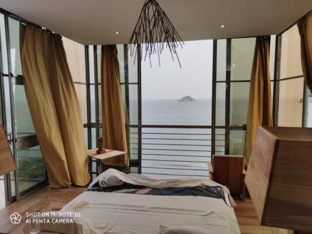 - une chambre avec un lit et une vue sur l'océan dans l'établissement Naam house, à SantʼAna