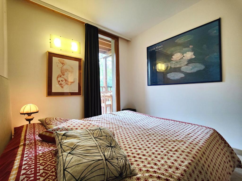 a bedroom with a bed and a picture on the wall at Hostdomus - Sansicario R21 in Cesana Torinese