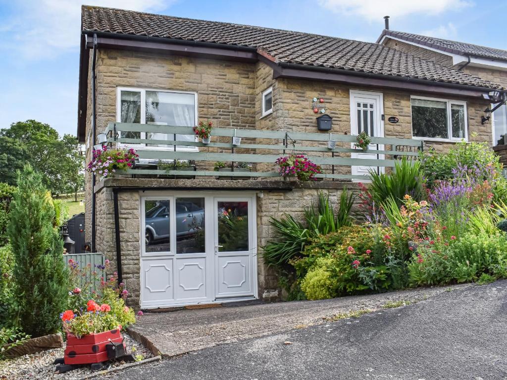 a brick house with a white door and a balcony at Ladybird Lodge in Glaisdale