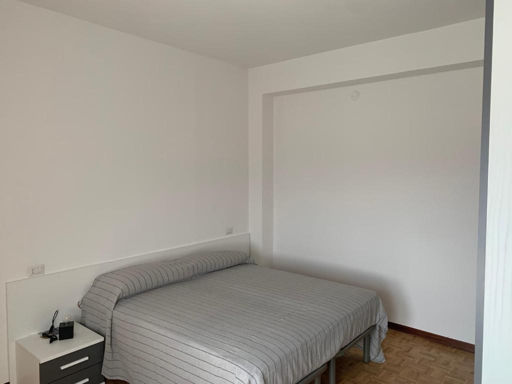 a small bed in a room with a white wall at Residence Salvatici in Castelnovo neʼ Monti