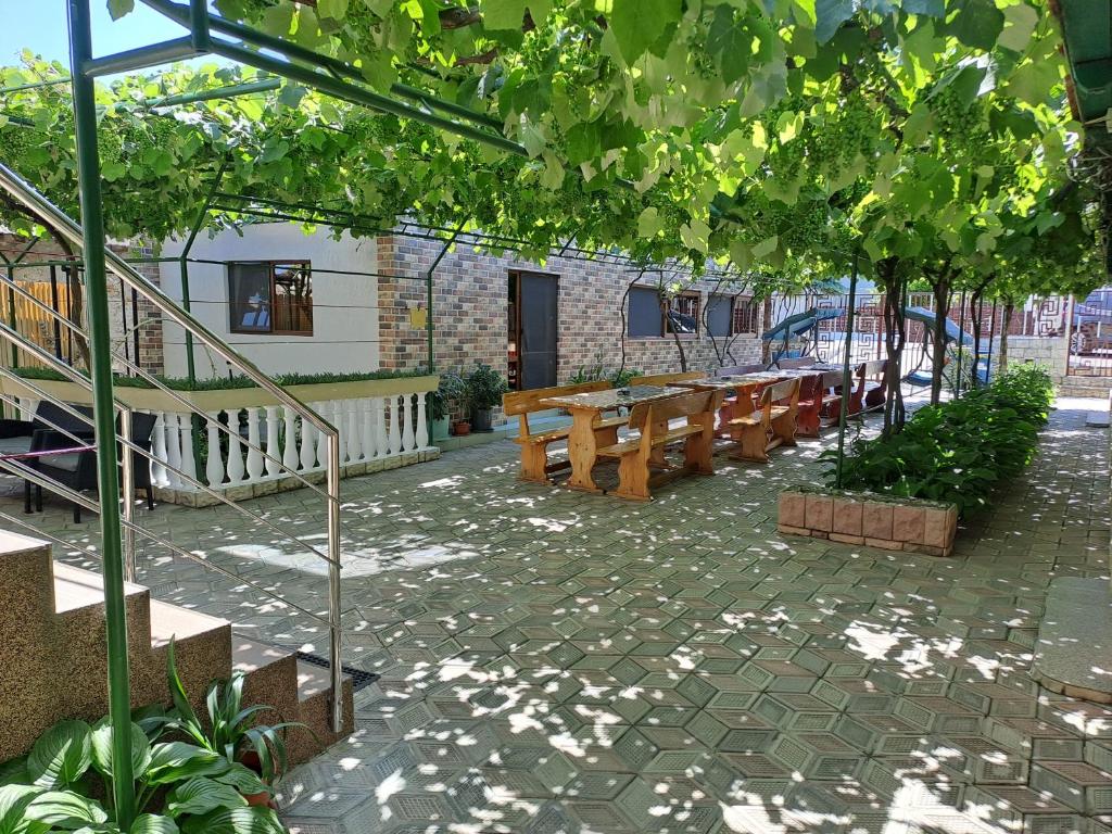 un patio con mesas de madera y bancos en un edificio en Casa Elena, en 2 Mai