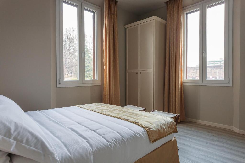 a bedroom with a bed and two windows at Affittacamere Angelica in Bologna