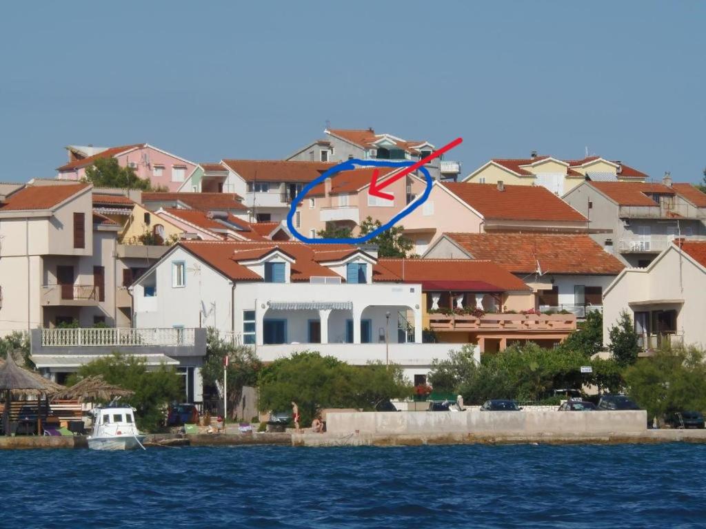 una cometa volando sobre un grupo de casas junto al agua en Apartments Pletikosa, en Brodarica