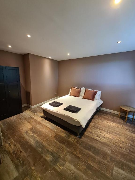 ein Schlafzimmer mit einem großen Bett und Holzboden in der Unterkunft Chateau Humieres Coach House in Humières
