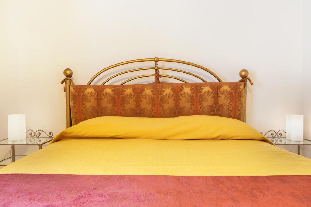 a bedroom with a yellow bed with two night stands at Hotel Casa Boccassini in Venice