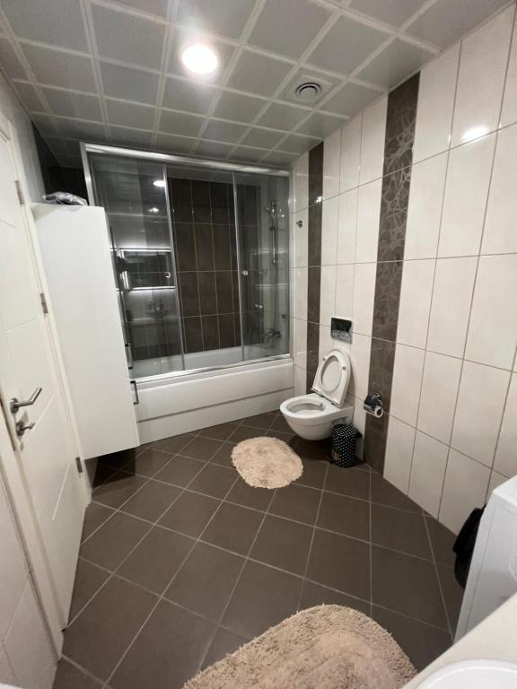 a bathroom with a toilet and a shower with a window at Akkoza Koru Bloklari in Esenyurt