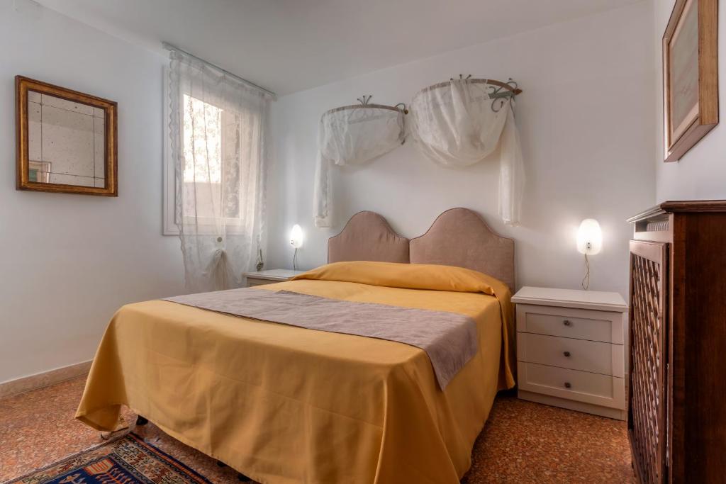 a bedroom with a bed with a yellow bedspread at Hotel Casa Boccassini in Venice