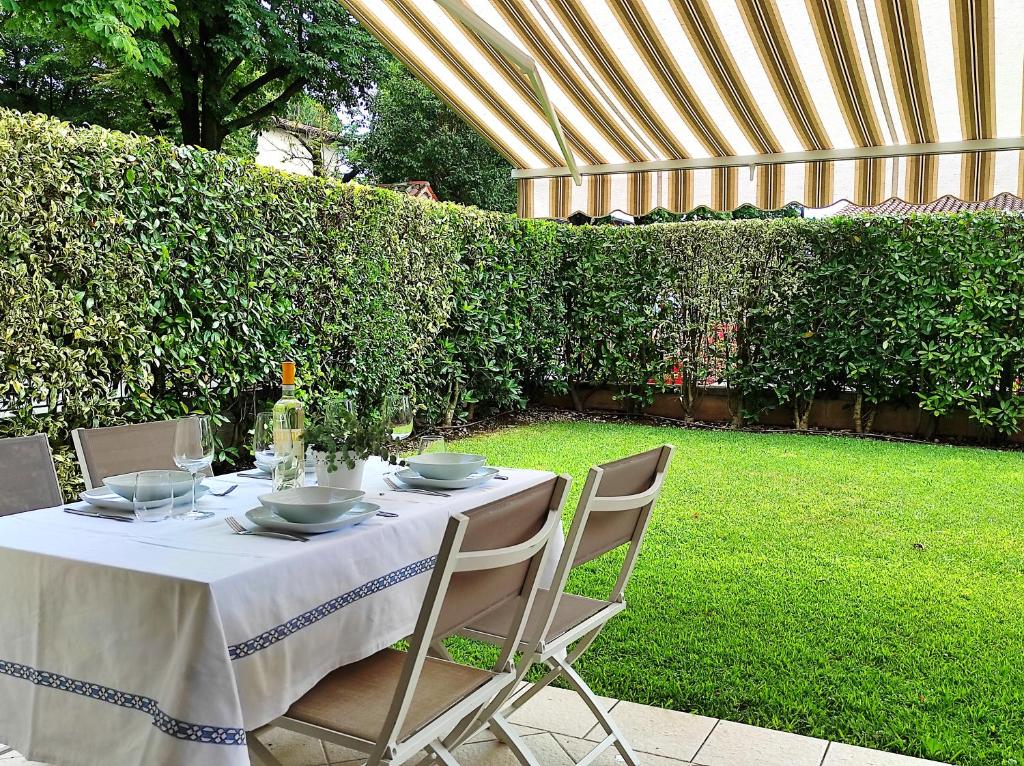 a table with a white table cloth and chairs in a garden at La Casa Di Cele in Desenzano del Garda