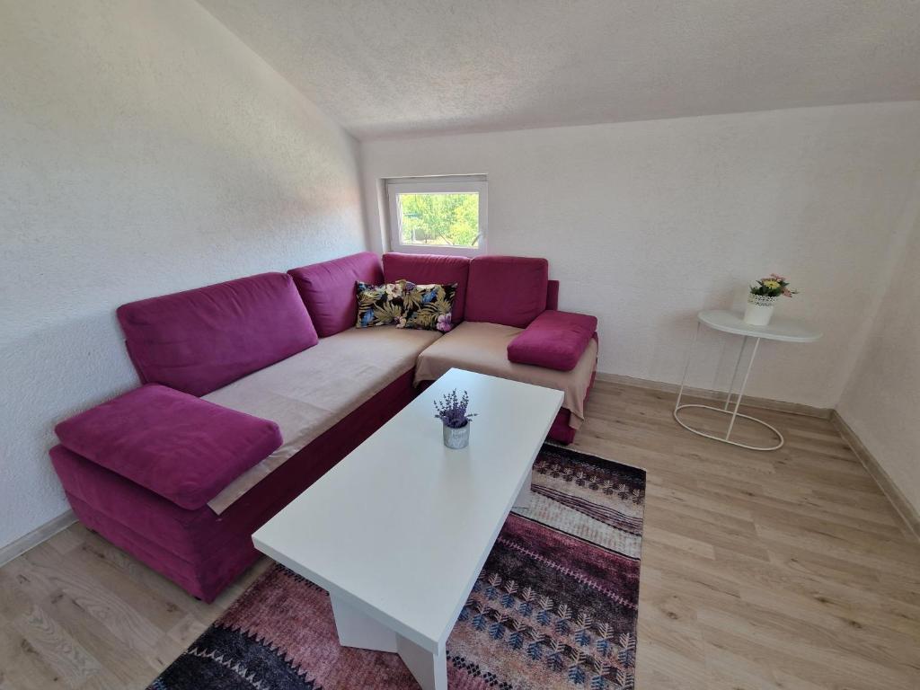 sala de estar con sofá púrpura y mesa en Sweet guesthouse en Mostar