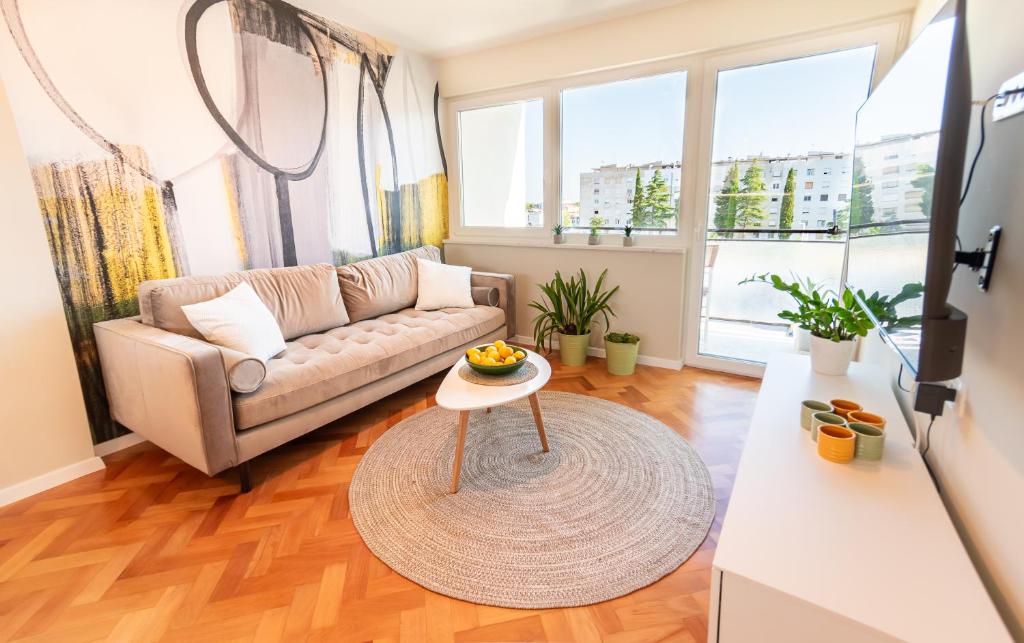una sala de estar con un sofá y una mesa en Apartment Veruda, en Pula