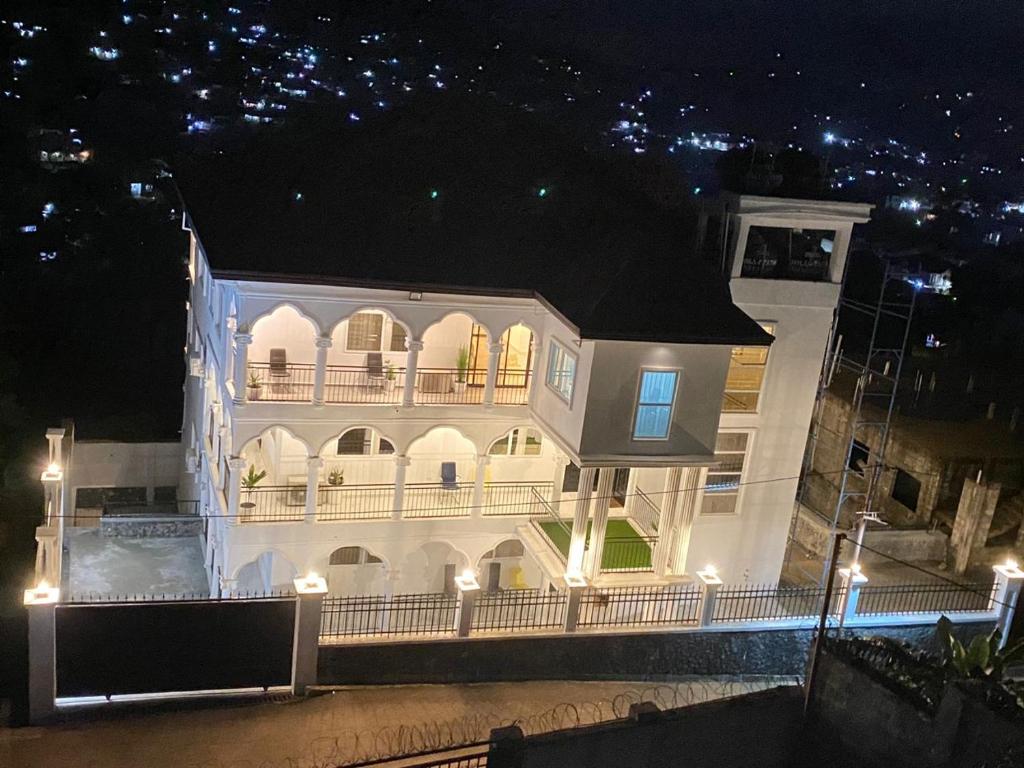 een groot wit gebouw met een balkon in de nacht bij After 5 Apartment 2 3 spacious en-suite bedrooms in Freetown