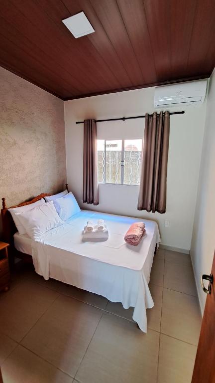 Schlafzimmer mit einem großen weißen Bett und einem Fenster in der Unterkunft Casa Acerola - Vila de São Jorge in Sao Jorge