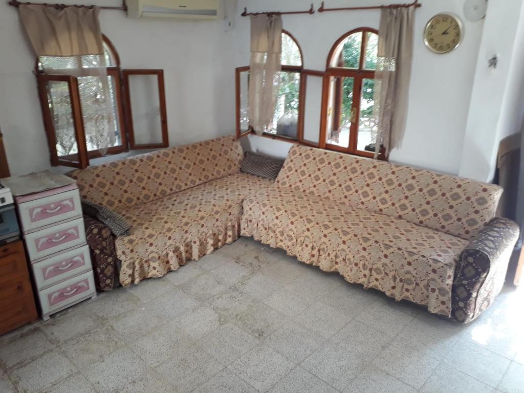 un grande divano in una camera con finestre di SEFERİHİSAR ÜRKMEZ DE KİRALIK YAZLIK a Ürkmez