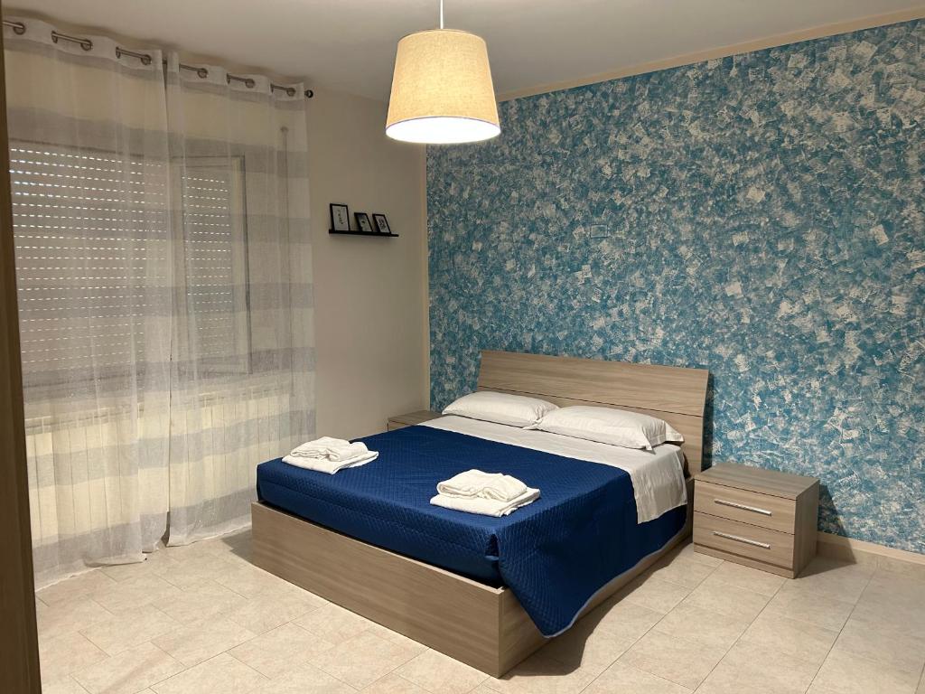 - une chambre avec un lit et un mur bleu dans l'établissement Villa GaribaldinA, à Treglio