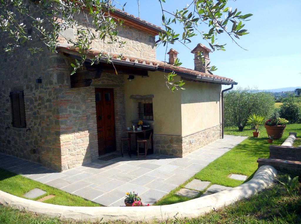 una casa de piedra con una mesa delante en Selva degli Ulivi, en Foiano della Chiana